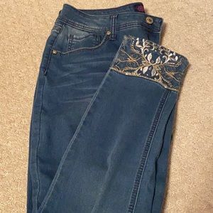 Mid-rise skinny jeans, ankles of pant have intricate lace, and beading design.